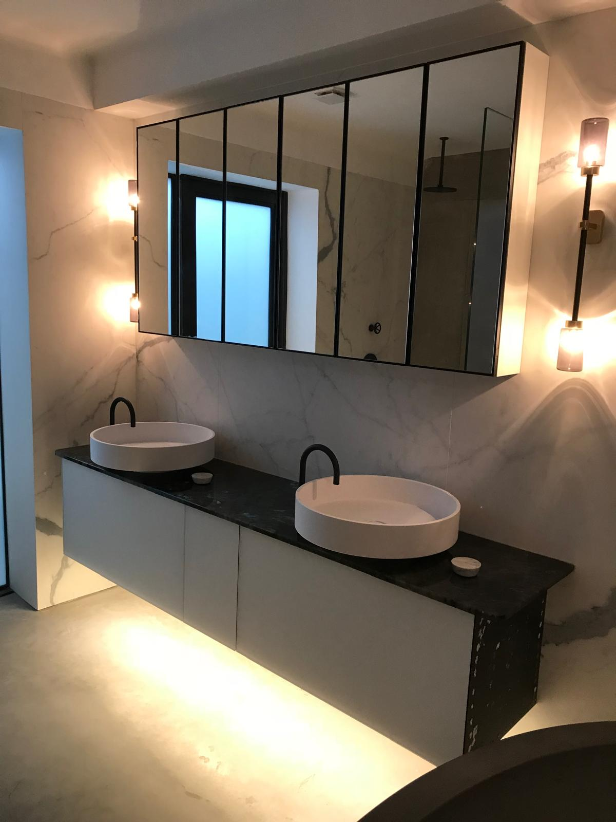 Luxury bathroom vanity with twin round basins, matt-black brassware and marble effect wall — full bathroom installation by Premier Heating